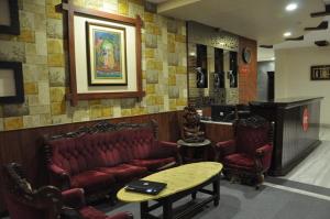 a waiting room with a couch and chairs and a table at Hotel Surbhi in Gwalior