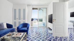 a living room with a blue couch and a table at Hotel Scalinatella in Capri