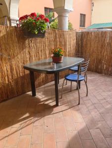 a table and a chair on a patio with flowers at Sweet home Lago di Garda in Prevalle