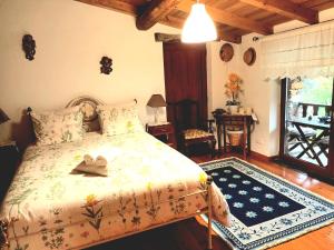 a bedroom with a bed with two shoes on it at A Casa da Natália in Alvares