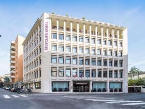 duży biały budynek na rogu ulicy w obiekcie Mercure Roma Piazza Bologna w Rzymie +37 zdjęć