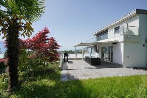 a white building with a palm tree in front of it at Montreux panoramic view with garden in Montreux