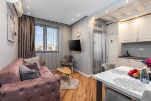 a living room with a pink couch and a kitchen at XIO Apartments in Bar