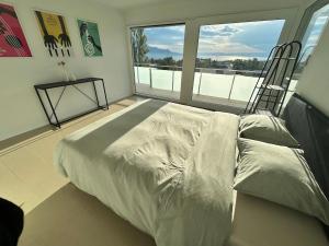 a bedroom with a bed and a large window at Montreux panoramic view with garden in Montreux