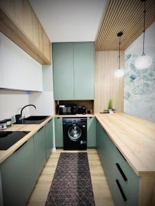 包姚Sugo Studio Apartman的厨房配有绿色橱柜和洗衣机。