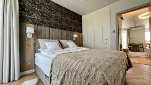 a bedroom with a large bed with a black wall at Apartament -Luksus- Nowa Dzielnica in Busko-Zdrój