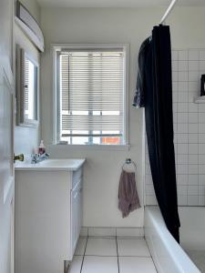 a bathroom with a sink and a tub and a window at Riverton Place NoHo in Los Angeles