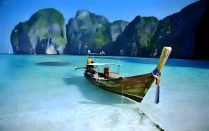 a boat in the water in front of a beach at BAO Patong Beach Phuket - เบา ป่าตอง in Patong Beach