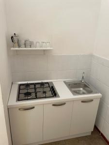 a white kitchen with a stove and a sink at Terrasini 2000 Casa Vacanze in Terrasini