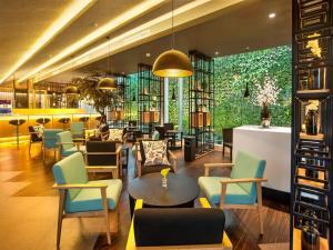 a lobby with chairs and tables and a bar at Tama Boutique Hotel in Bandung