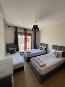 a bedroom with three beds and a chandelier at Appartement de rêve à Marrakech in Marrakech