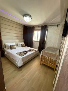 a bedroom with two beds and a television in it at Appartement de rêve à Marrakech in Marrakech +37 photos