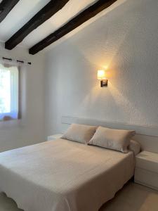 a bedroom with a bed with a light on the wall at Apartamentos LLorca in Platja de l’Almadrava +37 photos