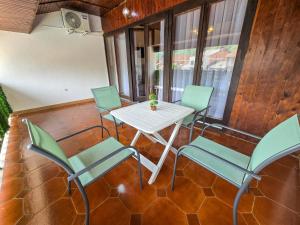 un patio con tavolo e sedie bianchi di OLDNEW Apartments & Rooms a Prizren