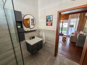 un bagno con lavandino e specchio di OLDNEW Apartments & Rooms a Prizren Altre 79 foto