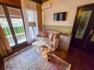 un soggiorno con un divano e un tavolo di OLDNEW Apartments & Rooms a Prizren
