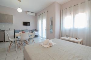 1 Schlafzimmer mit einem Bett, einer Küche und einem Tisch in der Unterkunft Almyra Apartments by RentalsPro - Hanioti Halkidiki in Chaniotis