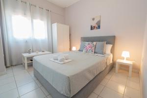 ein weißes Schlafzimmer mit einem großen Bett und einem Fenster in der Unterkunft Almyra Apartments by RentalsPro - Hanioti Halkidiki in Chaniotis