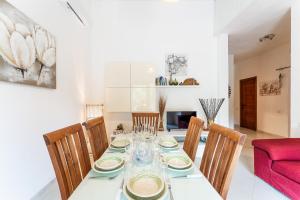 a dining room with a table with chairs and a red couch at Coral House Premium, 200m to beach in Pinus Village +16 photos