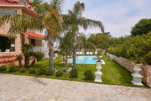a yard with palm trees and a swimming pool at Villa laura in Palermo +47 photos