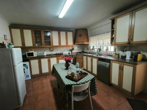 a kitchen with a table with flowers on it at Por A Mor in Figueiró dos Vinhos