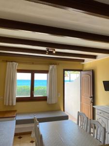a dining room with a table and a view of the ocean at Apartamentos LLorca in Platja de l’Almadrava