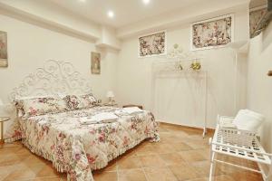 a white bedroom with a bed and a chair at Villa laura in Palermo