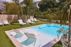 a swimming pool in a yard with chairs and a swimming pool at Villa laura in Palermo