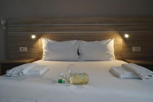 a white bed with a purse and towels on it at ROMANTZA apartments in Agia Marina Nea Kydonias