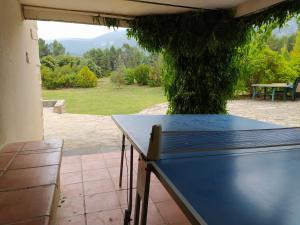 a blue table on a patio with a tree at casa rural Mas Pare Sant in Alcoy