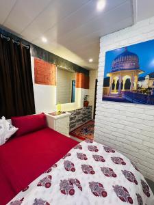a bedroom with a bed and a painting on the wall at Travellers Village in Jaipur