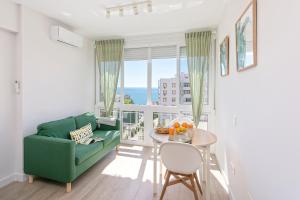 ein Wohnzimmer mit einer grünen Couch und einem Tisch in der Unterkunft Sunstay Cruz Loft Torremolinos in Torremolinos