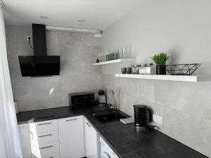 利耶帕亚Martas apartment的厨房配有白色橱柜和黑色台面