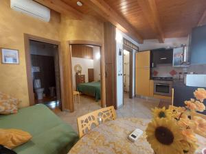 a living room with a table and a kitchen at Giardino Del Sole in Taormina