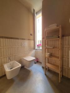 a bathroom with a toilet and a sink and a window at Cavallerizza flat in Brescia