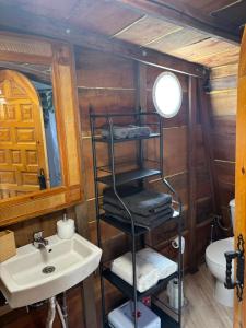 a bathroom with a sink and a shelf with towels at Pink Elephant in Lorca
