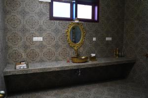a bathroom with a sink and a mirror on the wall at Room Suvira at Samava Farms Calicut in Kozhikode