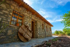 a stone house with a large wooden bowl on the side of it at BabaNu Guesthouse in Nënshat +7 photos