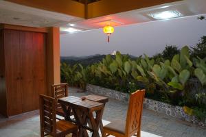 a table and chairs on a patio with a view at Room Suvira at Samava Farms Calicut in Kozhikode
