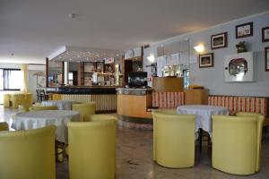 un restaurante con mesas blancas y sillas amarillas en Hotel Rosy, en Bellaria-Igea Marina 58 fotos más