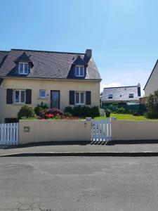 a white fence in front of a house at Maison de la fontaine in Saint-Méloir-des-Ondes