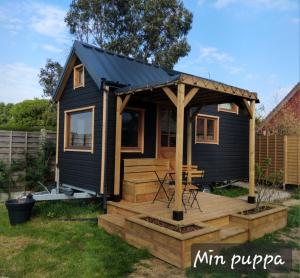 Quesnoy-le-MontantTiny House Min puppa proche Baie de Somme的一座带凉亭的黑色小房子
