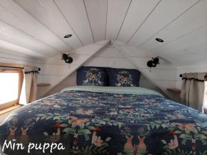a bed in the middle of a room at Tiny House Min puppa proche Baie de Somme in Quesnoy-le-Montant