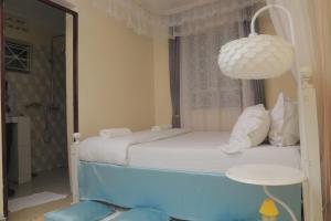 ein Schlafzimmer mit zwei Betten und einem Kronleuchter in der Unterkunft Beautiful Spaces 3 bedroomed bungalow in Kira + 37 Fotos