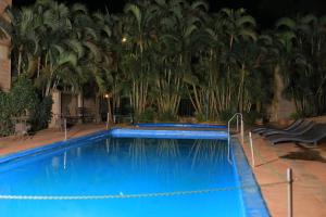 ein großer blauer Pool mit Palmen im Hintergrund in der Unterkunft Beautiful Spaces 3 bedroomed bungalow in Kira