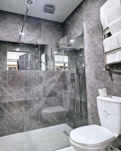 une salle de bains avec douche, toilettes et lavabo dans l'établissement Elegant apartments in the city center Brewery, à Rivne