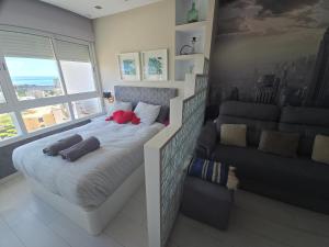 a bedroom with a large bed and a couch at Estudio I vistas mar, cerca tren y Malaga in Torremolinos