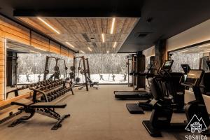 a gym with rows of treadmills and exercise equipment at Sośnica Resort & SPA in Zakopane