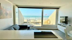a living room with a couch and a large window at Seanest - North Sea Stays in De Haan +17 photos