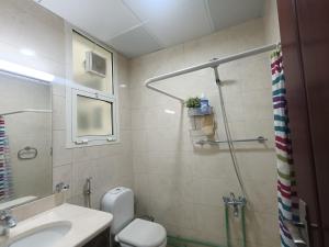a bathroom with a toilet and a sink and a shower at Good place for stay in Al Ain